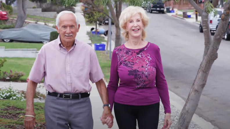 Image of Maureen and Dennis smiling and walking towards the camera 