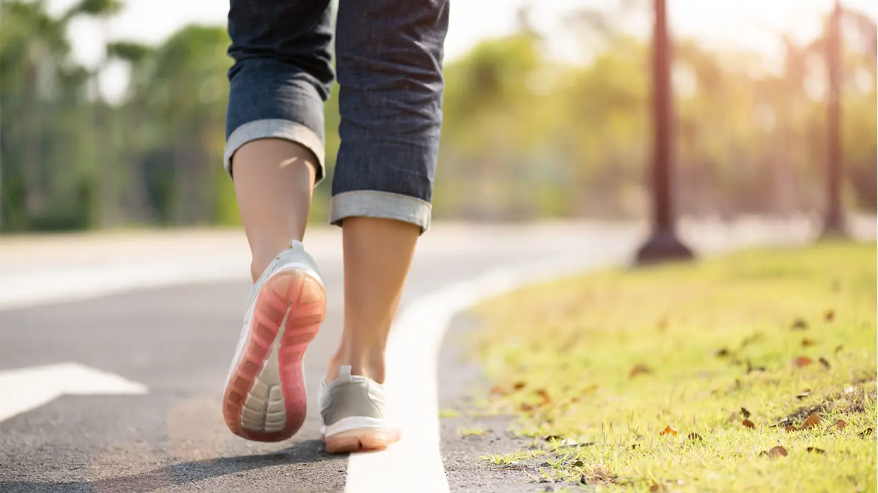 Close-up of a woman walking along the side of a path