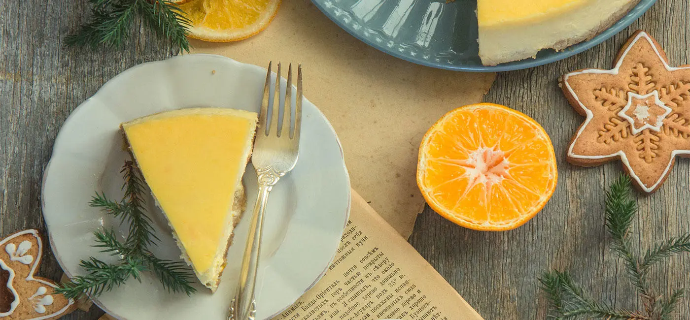 Festive table with ginger bread star cookies, orange segments and cheesecake. 