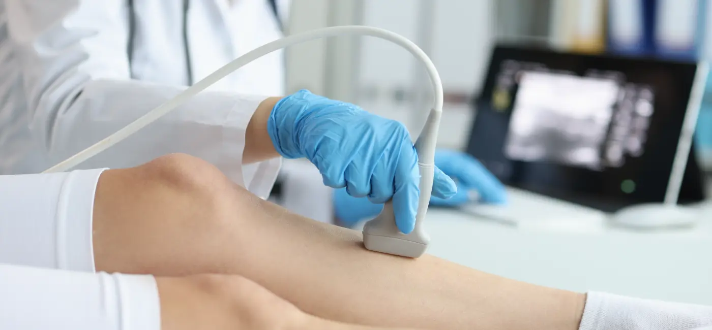 Doctor using ultrasound on leg to test circulation 