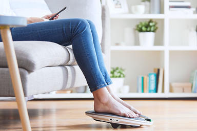Woman with her feet on a coach device