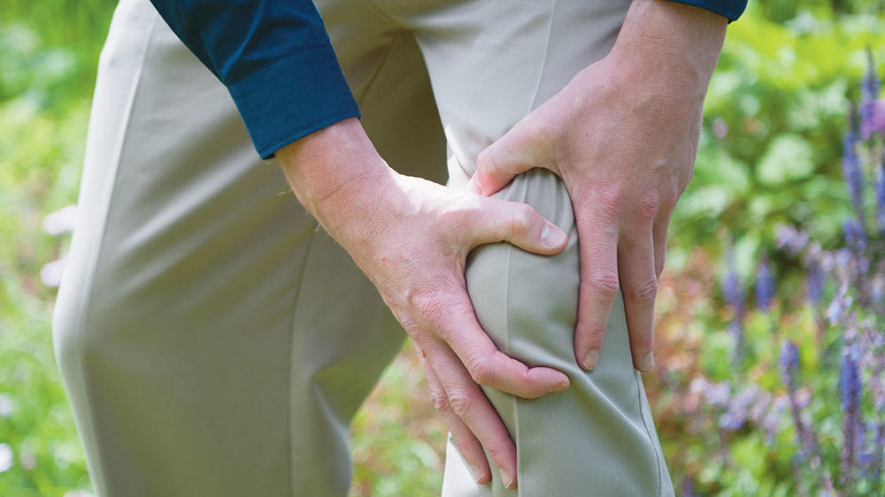 Man holding his knee