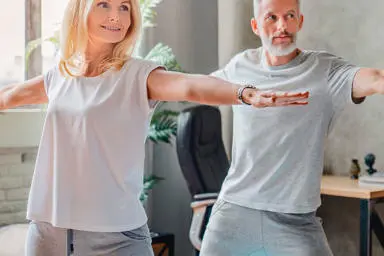 Couple in their lounge doing yoga