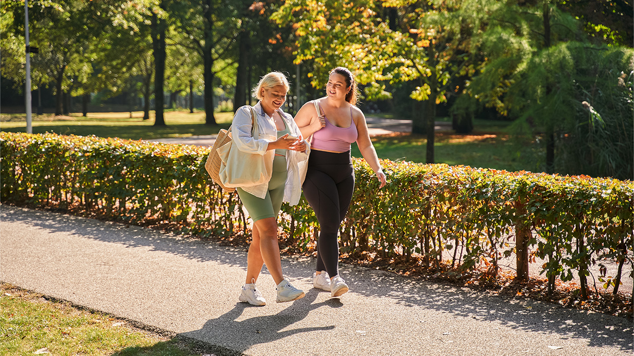 Two friends walking through the park 