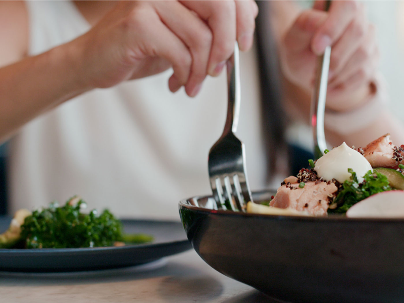 Image of a woman eating a bowl of healthy food 