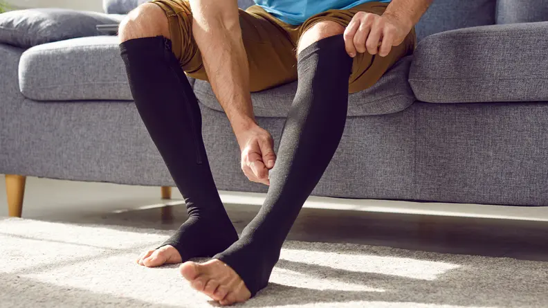 Image of a man putting on compression socks