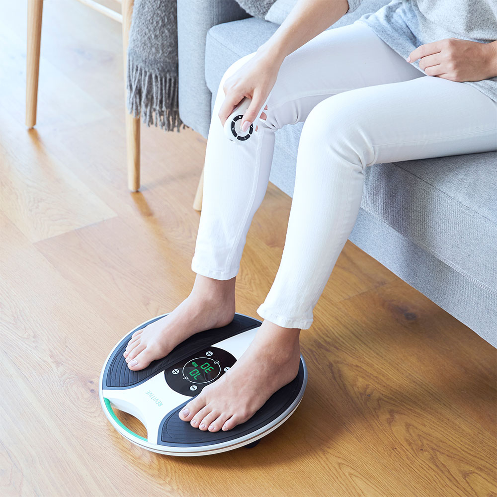 close up image of lady with her feet on the medic device holding the remote