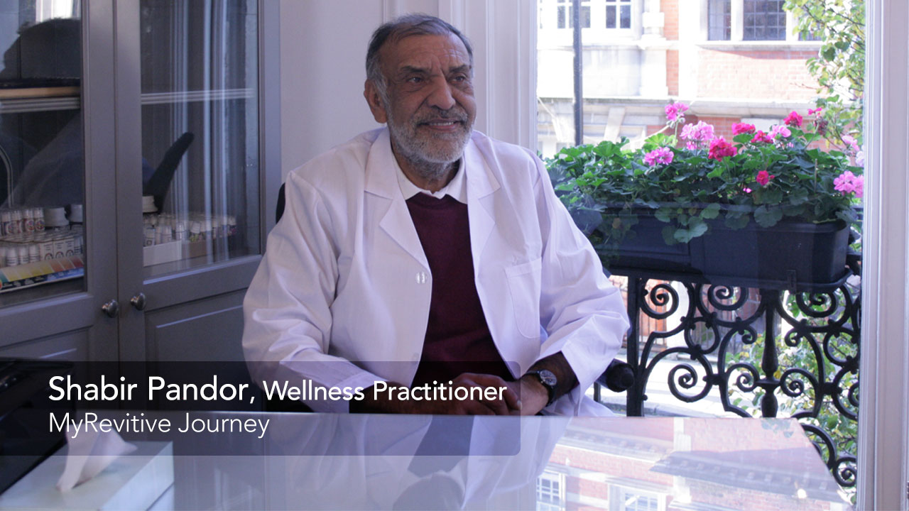 Image of Shabir Pandor in a while doctors coat smiling and talking to the camera