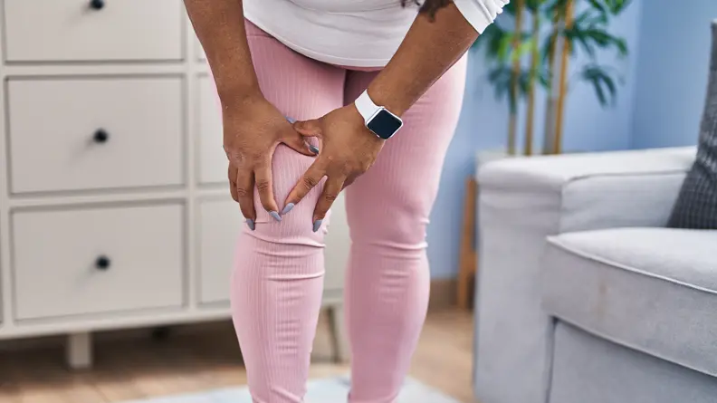 Image of a woman standing while crabbing her knee