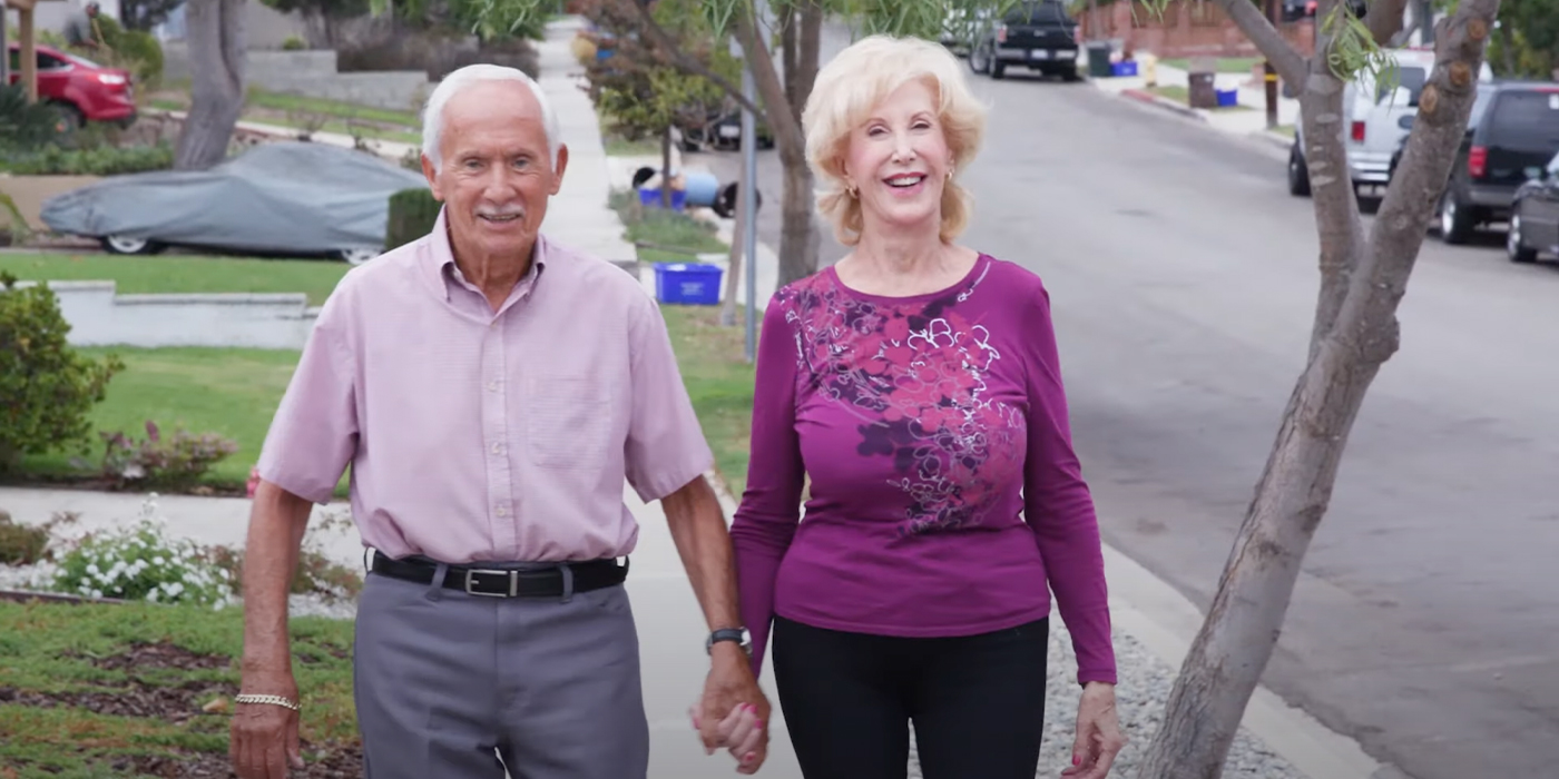 Image of Maureen and Dennis smiling and walking towards the camera 